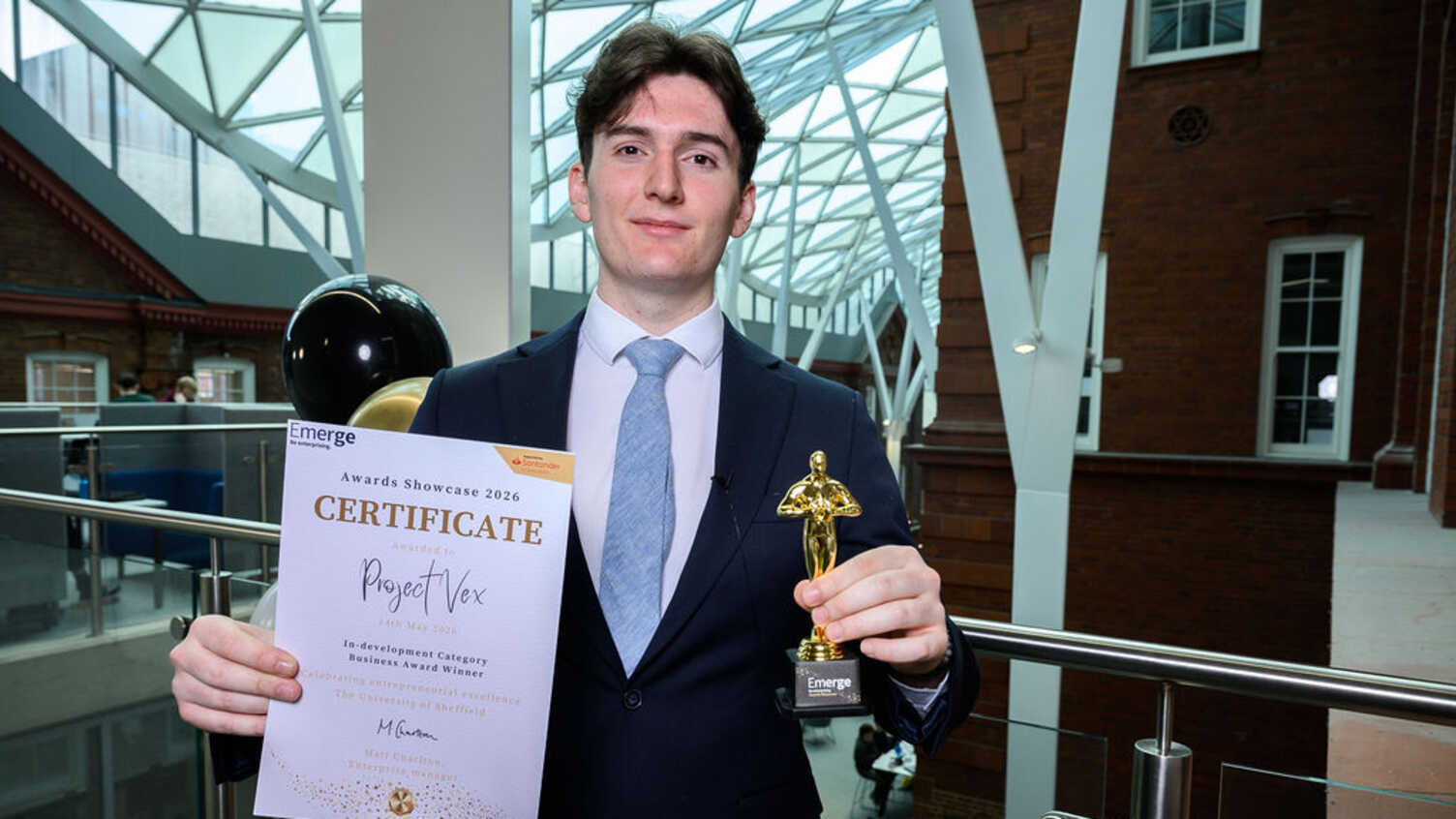 James holding the Project VEX award certificate and trophy